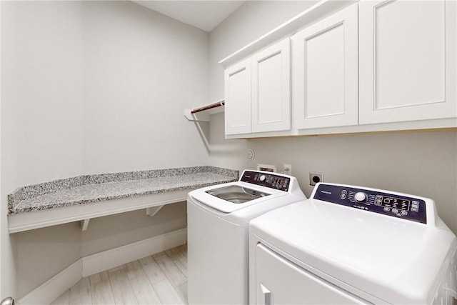 laundry area with independent washer and dryer and cabinets