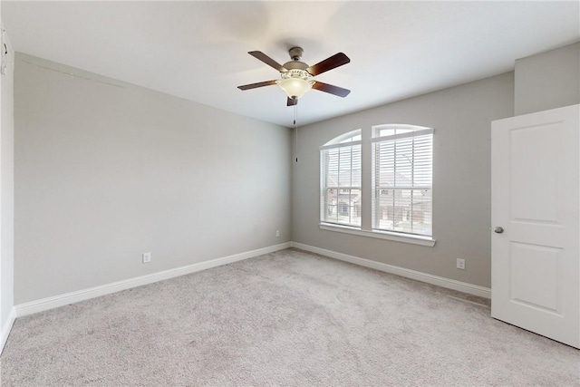 spare room with ceiling fan and light carpet