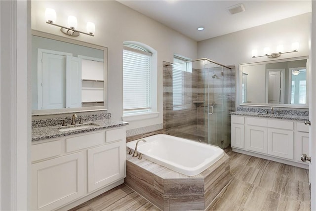 bathroom with shower with separate bathtub and vanity