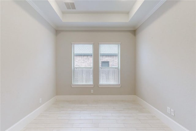 empty room with a tray ceiling and ornamental molding