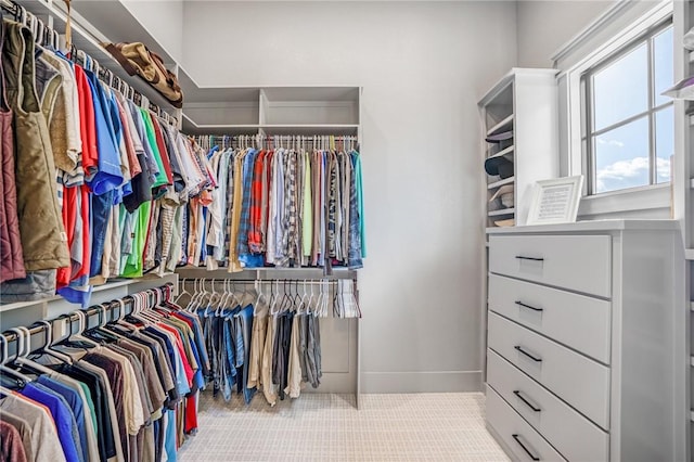 walk in closet featuring light colored carpet