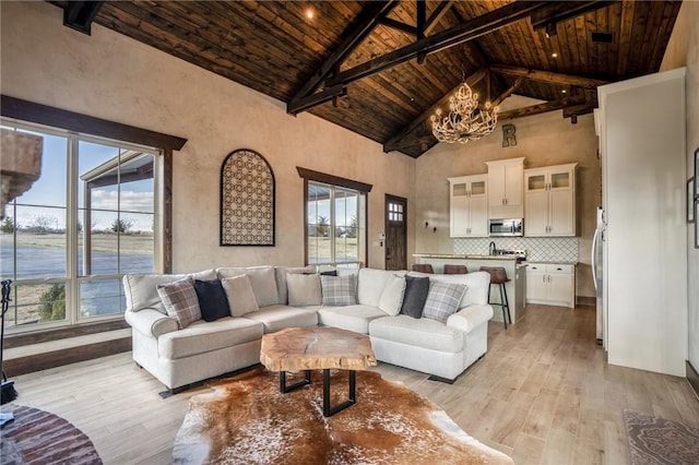 living room featuring light hardwood / wood-style flooring, high vaulted ceiling, and a wealth of natural light