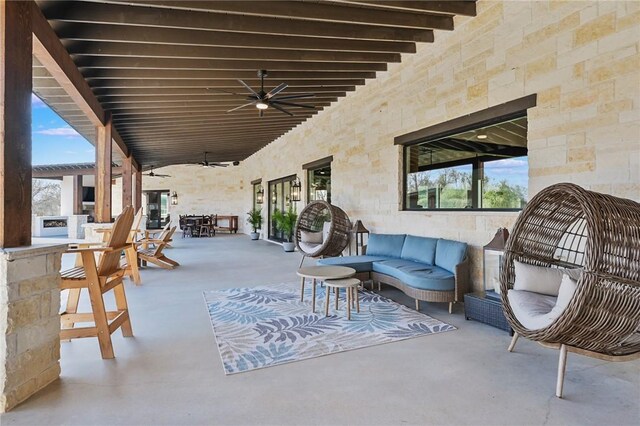 view of patio featuring ceiling fan, exterior bar, and an outdoor hangout area