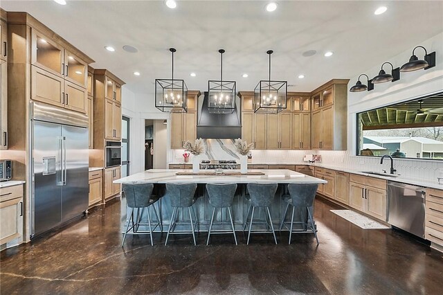 kitchen with a kitchen island with sink, sink, decorative light fixtures, a kitchen bar, and stainless steel appliances