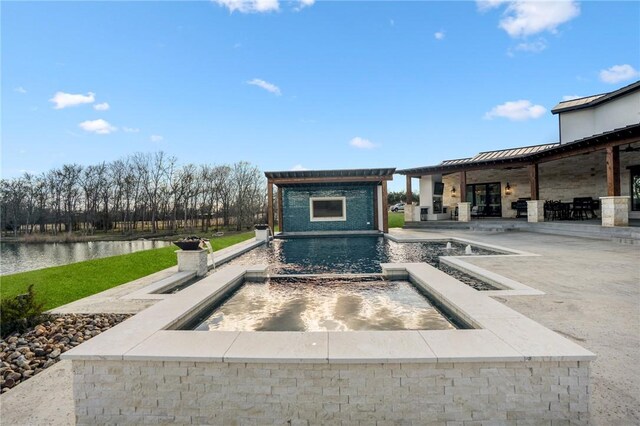 view of pool featuring a fireplace, a patio area, a water view, and an in ground hot tub