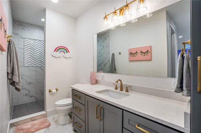 bathroom featuring tiled shower, vanity, and toilet