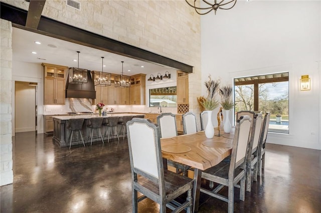 dining space featuring plenty of natural light, a towering ceiling, and sink