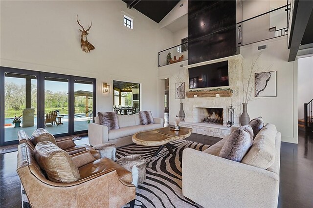 living room featuring high vaulted ceiling and a stone fireplace