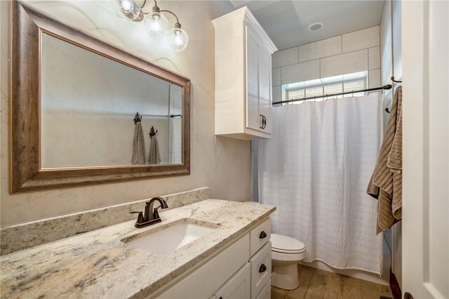 full bathroom with hardwood / wood-style floors, vanity, shower / bath combination with curtain, and toilet