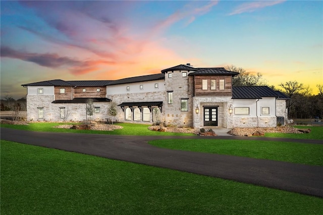 view of front facade featuring a lawn and french doors