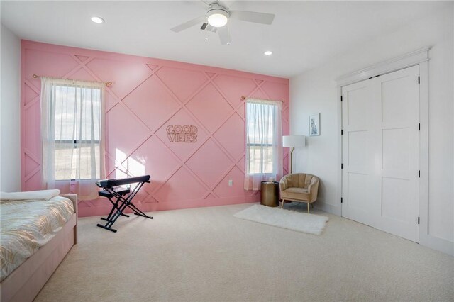 bedroom with light carpet, multiple windows, and ceiling fan