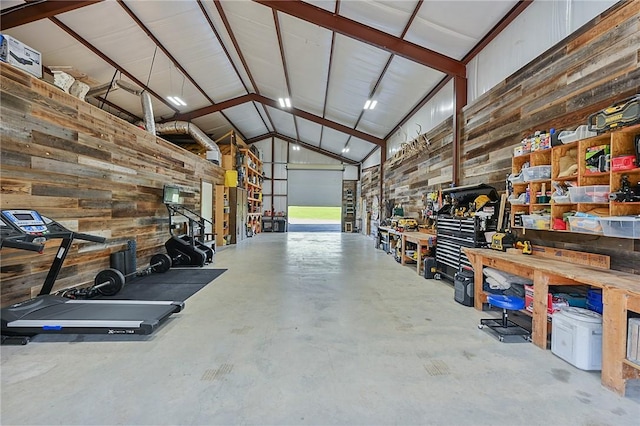 garage featuring a workshop area and wood walls