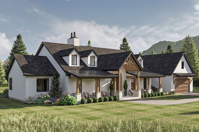 view of front of house featuring a porch, a garage, a mountain view, and a front yard