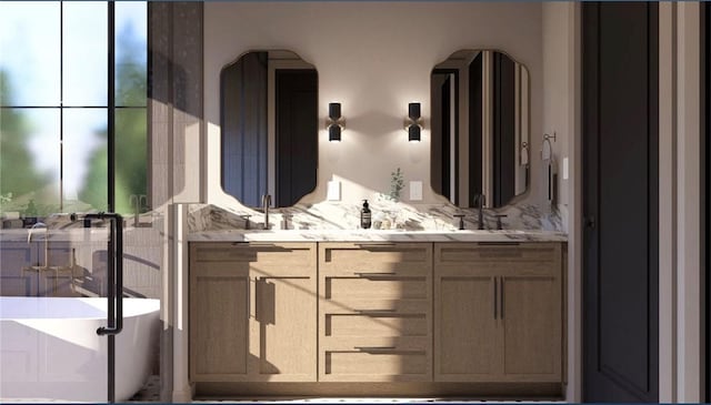 bathroom with a bathing tub, a wealth of natural light, and vanity