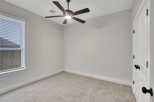 spare room featuring light carpet and ceiling fan