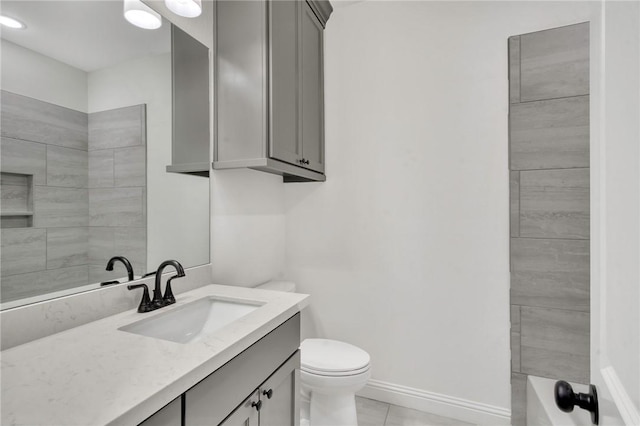 bathroom with tile patterned flooring, vanity, and toilet