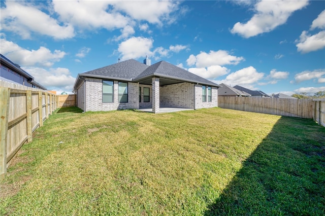 back of house with a patio and a lawn