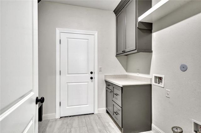 washroom featuring cabinets, light wood-type flooring, and hookup for a washing machine