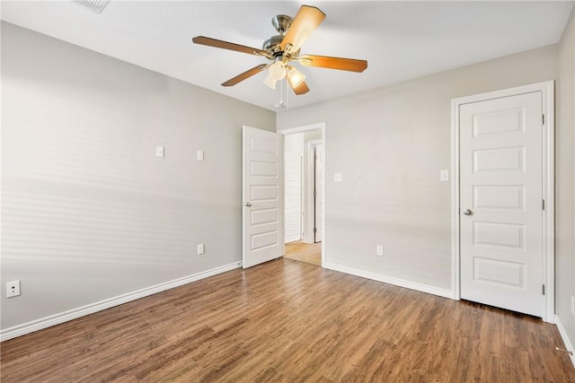 empty room featuring ceiling fan and dark hardwood / wood-style flooring