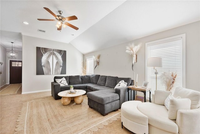 tiled living room with lofted ceiling and ceiling fan with notable chandelier