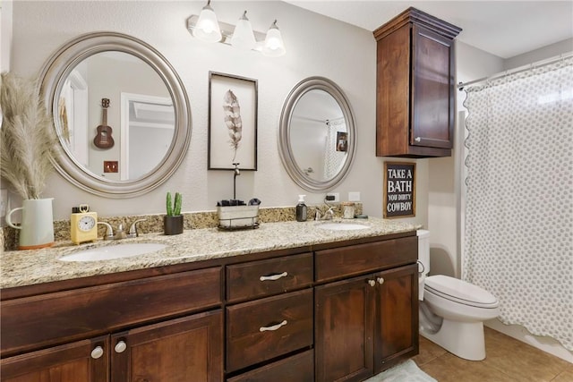 bathroom with a shower with curtain, vanity, tile patterned floors, and toilet