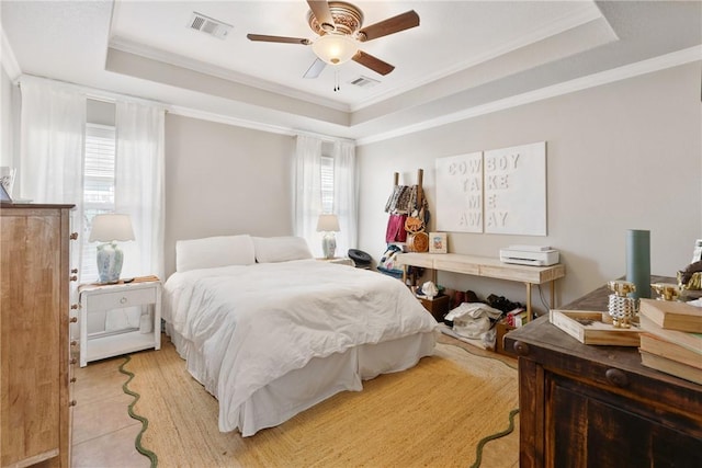 bedroom with ornamental molding, ceiling fan, and a tray ceiling