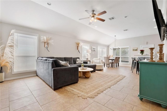 living room with ceiling fan with notable chandelier, vaulted ceiling, and light tile patterned floors