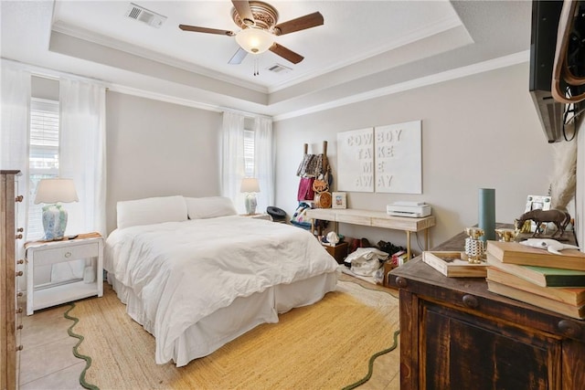 bedroom with crown molding, ceiling fan, and a tray ceiling