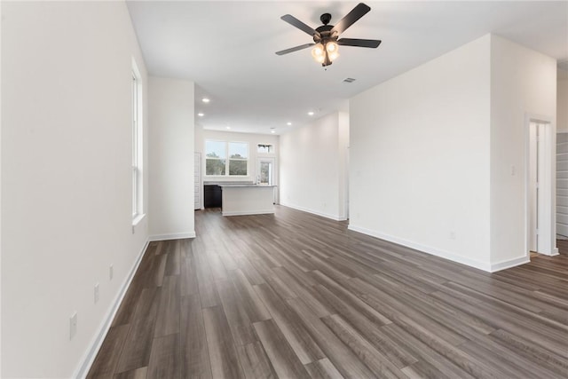 unfurnished living room with dark wood-type flooring and ceiling fan