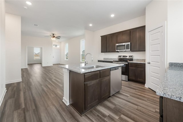 kitchen featuring sink, dark wood-type flooring, appliances with stainless steel finishes, dark brown cabinetry, and a healthy amount of sunlight