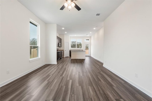 unfurnished living room featuring dark hardwood / wood-style floors and ceiling fan