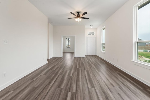 unfurnished living room with ceiling fan, plenty of natural light, and dark hardwood / wood-style floors