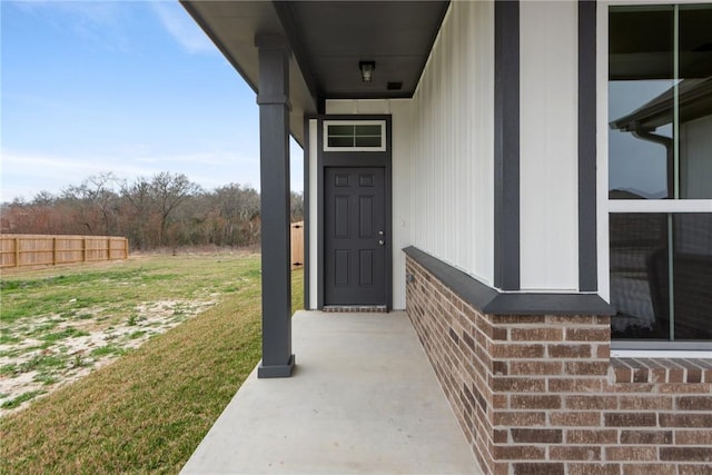 view of exterior entry featuring a lawn