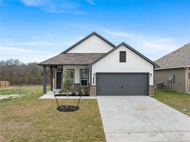 view of front of home featuring a garage, a front lawn, and central air condition unit