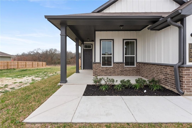 doorway to property with a yard and a porch