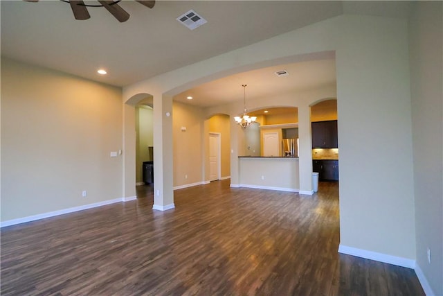 unfurnished living room featuring dark hardwood / wood-style floors and ceiling fan with notable chandelier