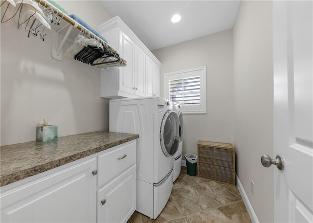 washroom with washing machine and dryer and cabinets