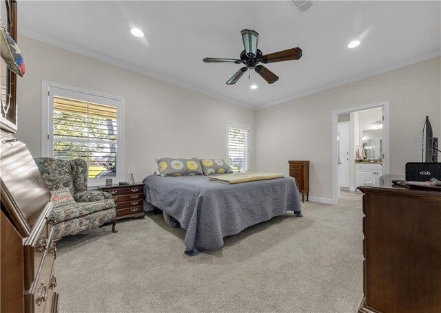 bedroom featuring ceiling fan, light colored carpet, ornamental molding, and connected bathroom