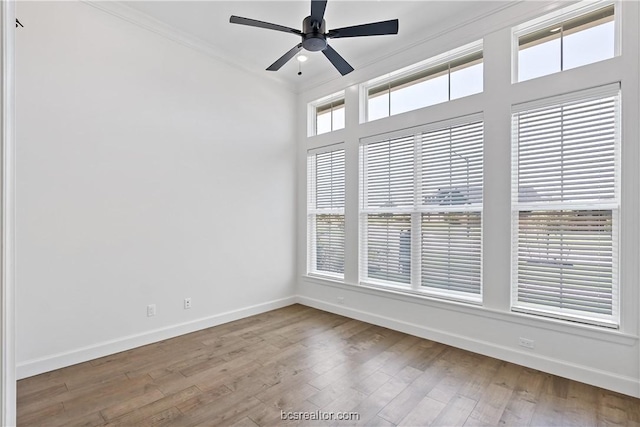 unfurnished room featuring light wood-type flooring, a wealth of natural light, ornamental molding, and ceiling fan