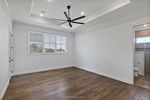 unfurnished room featuring a raised ceiling, a wealth of natural light, and dark wood-type flooring