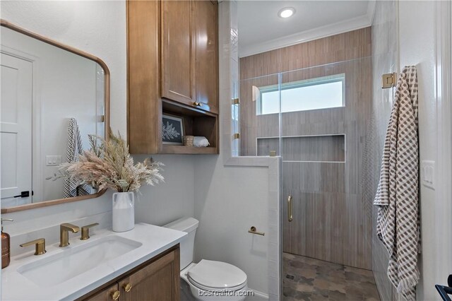 bathroom featuring toilet, vanity, ornamental molding, and walk in shower