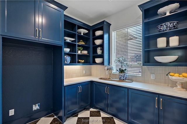 interior space featuring light tile patterned floors, backsplash, and blue cabinets