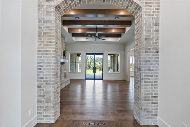 unfurnished living room with beam ceiling, dark hardwood / wood-style floors, and ceiling fan