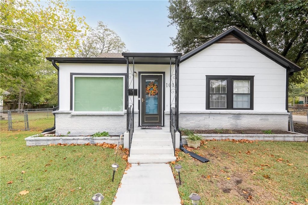 single story home featuring a front lawn