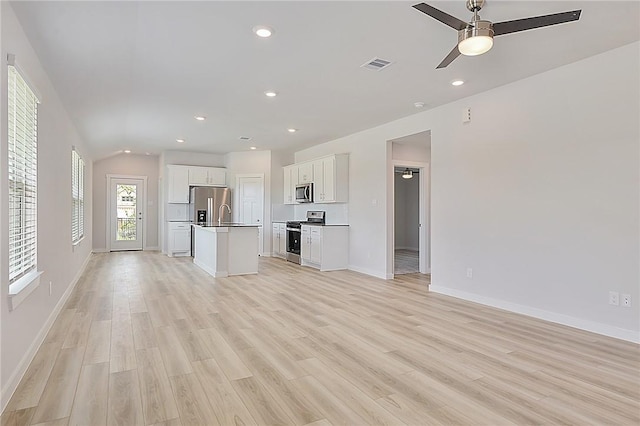 unfurnished living room featuring baseboards, a ceiling fan, light wood-style floors, and visible vents