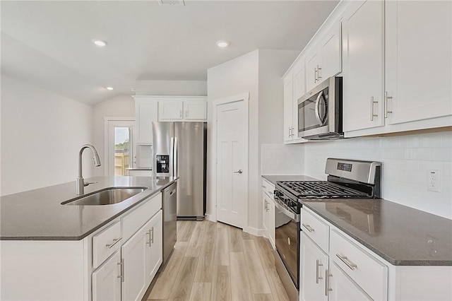 kitchen featuring a sink, light wood-type flooring, recessed lighting, decorative backsplash, and appliances with stainless steel finishes