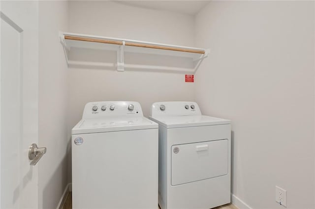 laundry area featuring baseboards, washer and dryer, and laundry area