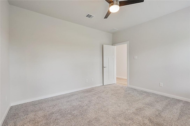 spare room featuring baseboards, visible vents, a ceiling fan, and light colored carpet