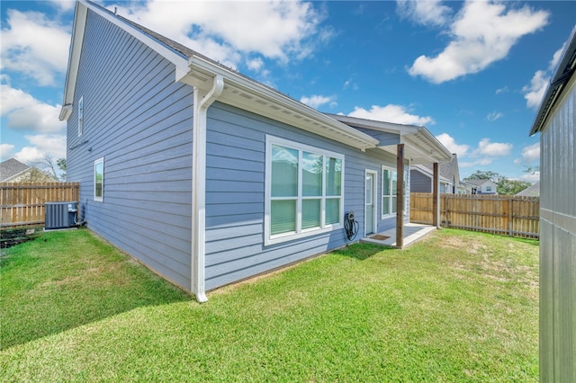 back of property featuring a lawn and central AC