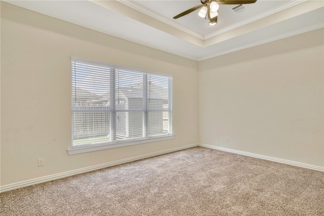 unfurnished room featuring a raised ceiling, ceiling fan, carpet floors, and ornamental molding